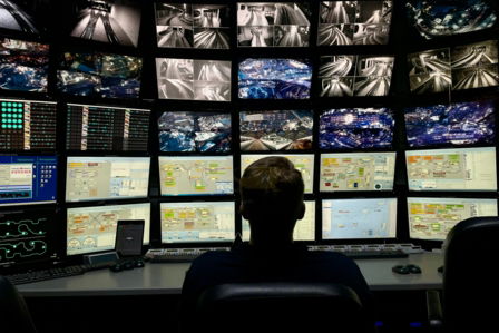 a man sitting in front of multiple monitors